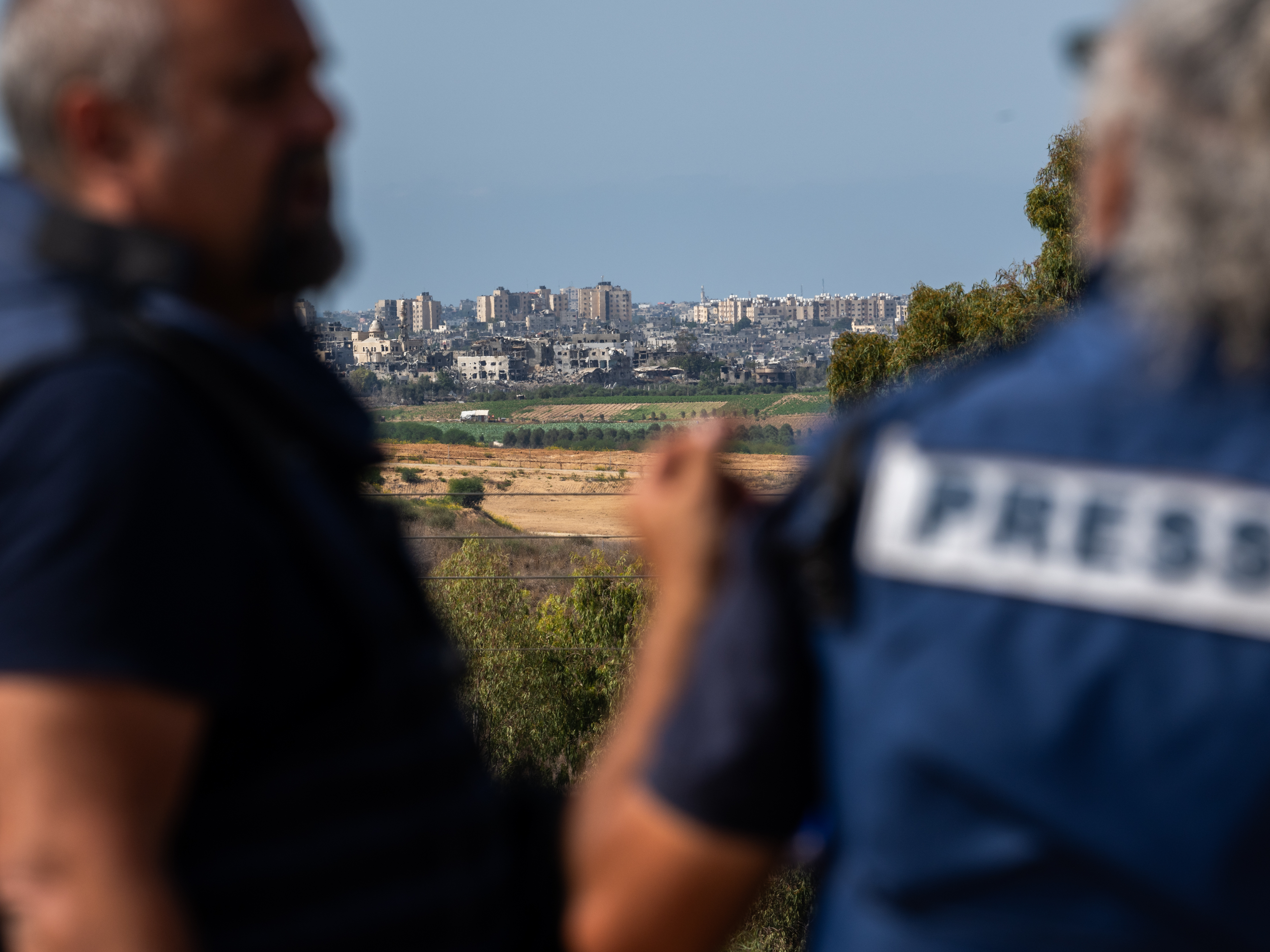 caption: Members of the press wait on an overlook in Sderot, Israel, to report on the fighting in Gaza on Oct. 21.
