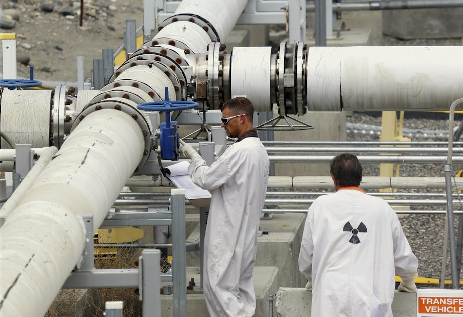 caption: In this July 9, 2014, file photo, workers wearing protective clothing and footwear inspect a valve at the "C" tank farm on the Hanford Nuclear Reservation near Richland, Wash. CREDIT: TED S. WARREN