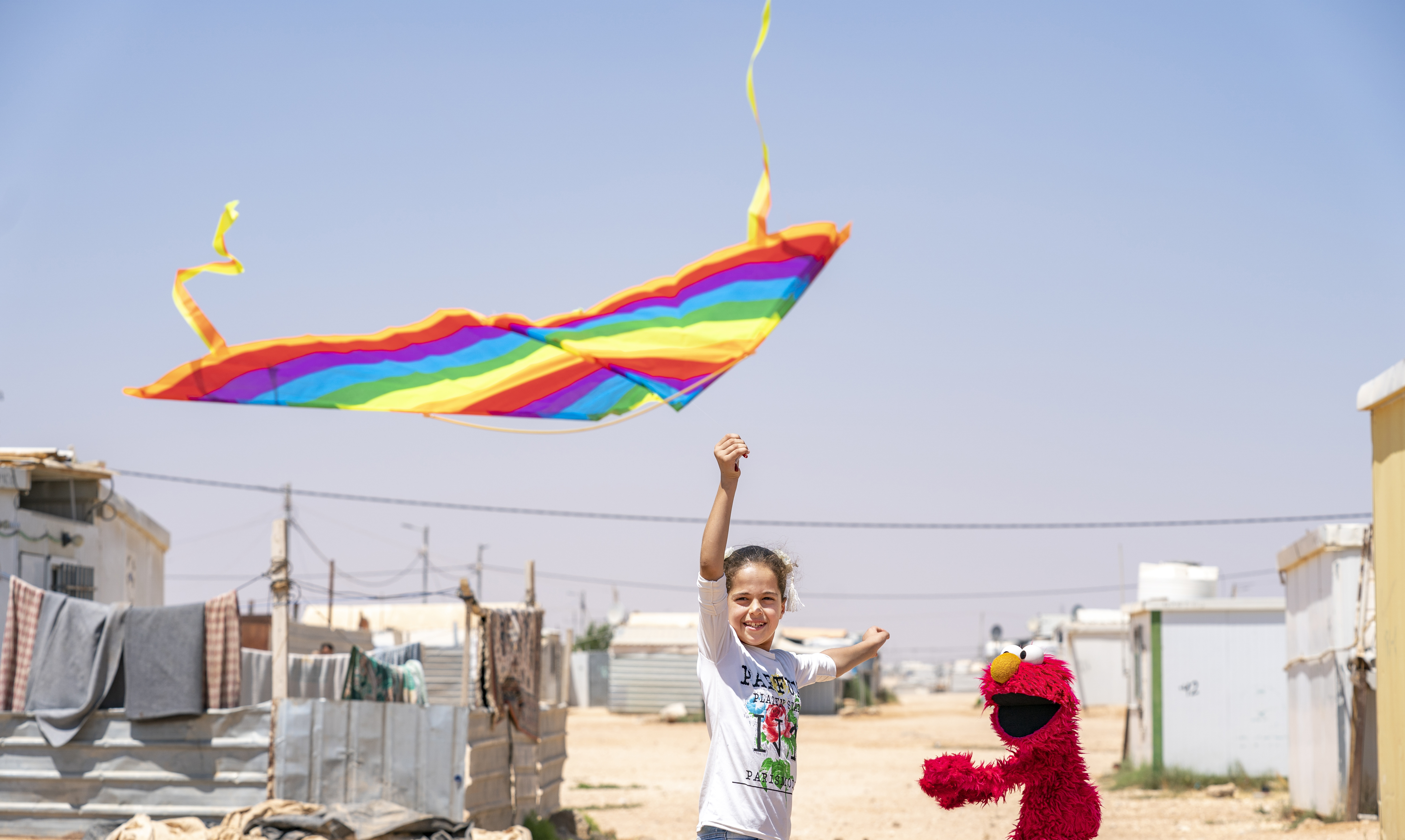 caption: In 2017, Sesame Workshop and the International Rescue Committee became the first winners of 100&Change for their work with children in the Middle East<em>.</em> Above, Elmo learns how to fly a kite at Azraq Camp, Jordan.