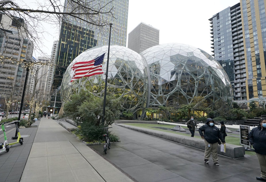 caption: A U.S. flag flies in front of the Amazon Spheres on the company's corporate campus in downtown Seattle, Tuesday, Dec. 7, 2021.