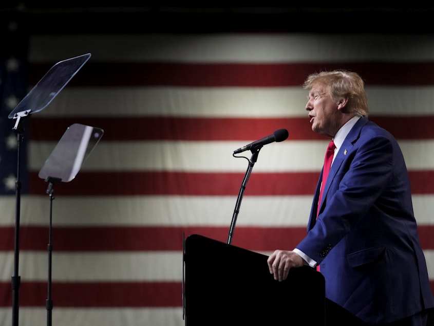 caption: Former President Donald Trump speaks during a rally Sunday, Dec. 17, 2023, in Reno, Nev. In a brief filed Saturday, Trump asked a federal appeals court to dismiss an election interference case against him, arguing he's immune from prosecution.