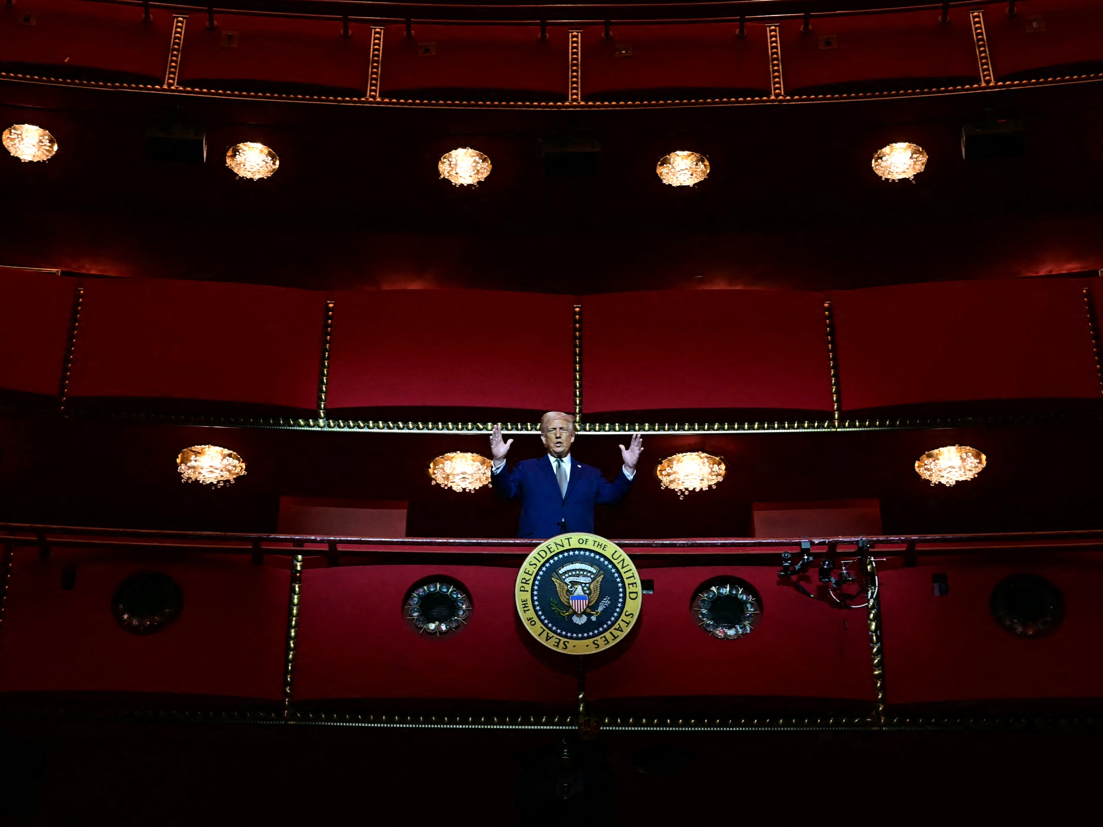 caption: President Donald Trump stands in the presidential box as he visits the John F. Kennedy Center for the Performing Arts in Washington, D.C, on March 17, 2025.