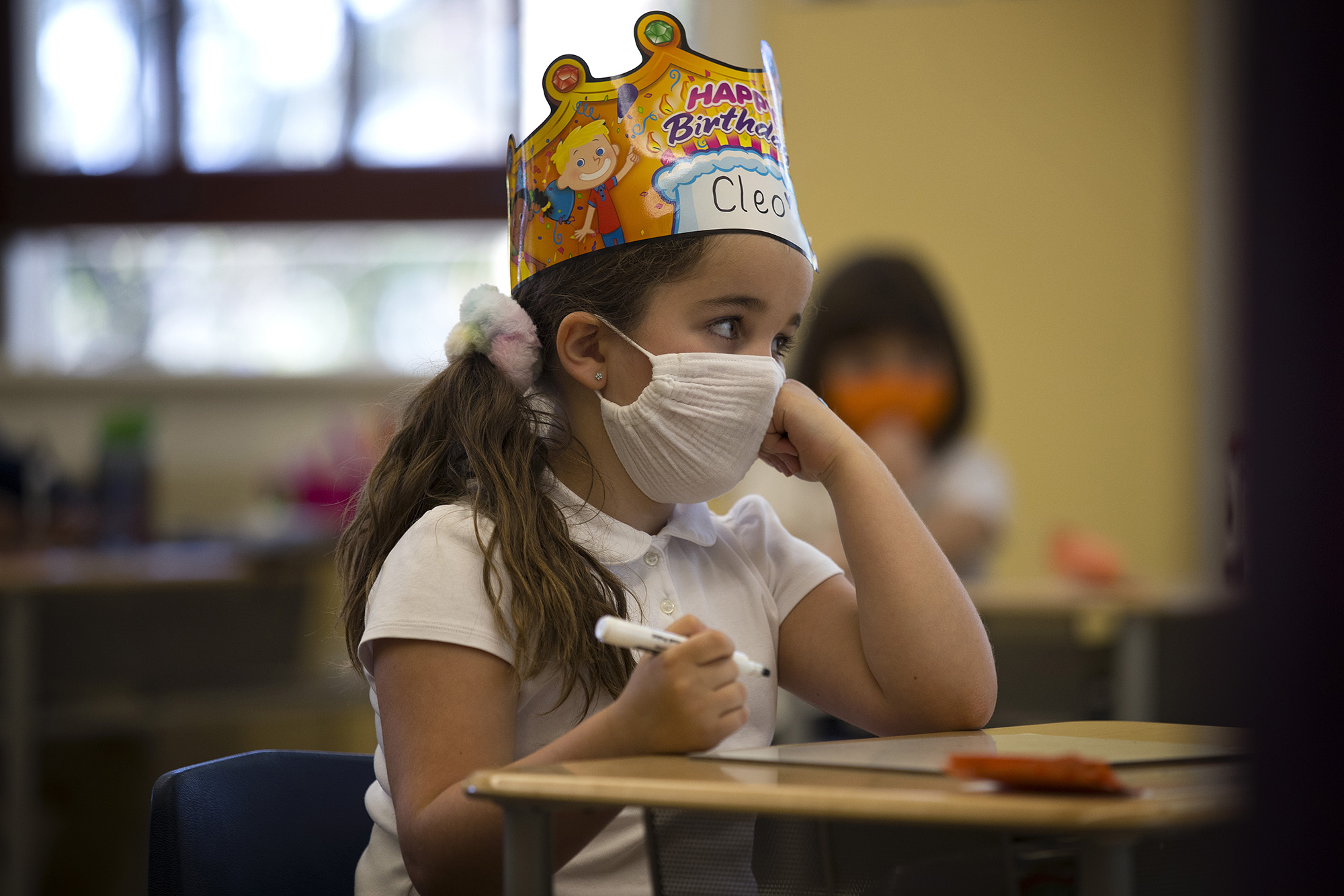 caption: Cleo, a first-grade student at Villa Academy, learns about vowels in teacher Kate Ford's classroom on Tuesday, April 20, 2021, in Seattle.