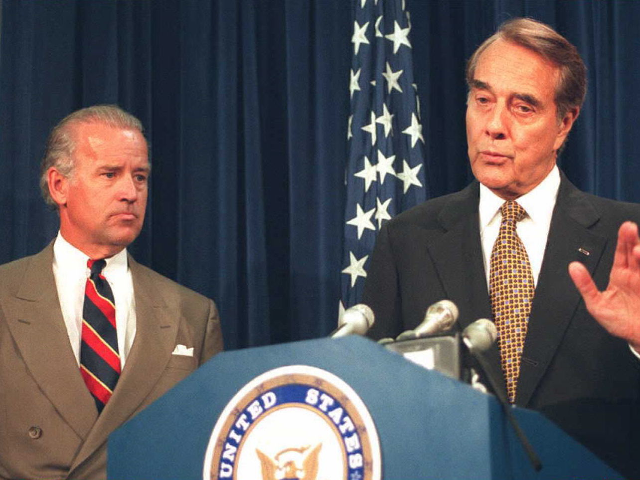 caption: Then U.S. Senate Majority Leader Robert Dole (right) speaks to reporters about the Senate vote to lift the arms embargo over Bosnia on July 26, 1995, as then Sen. Joseph Biden looks on.