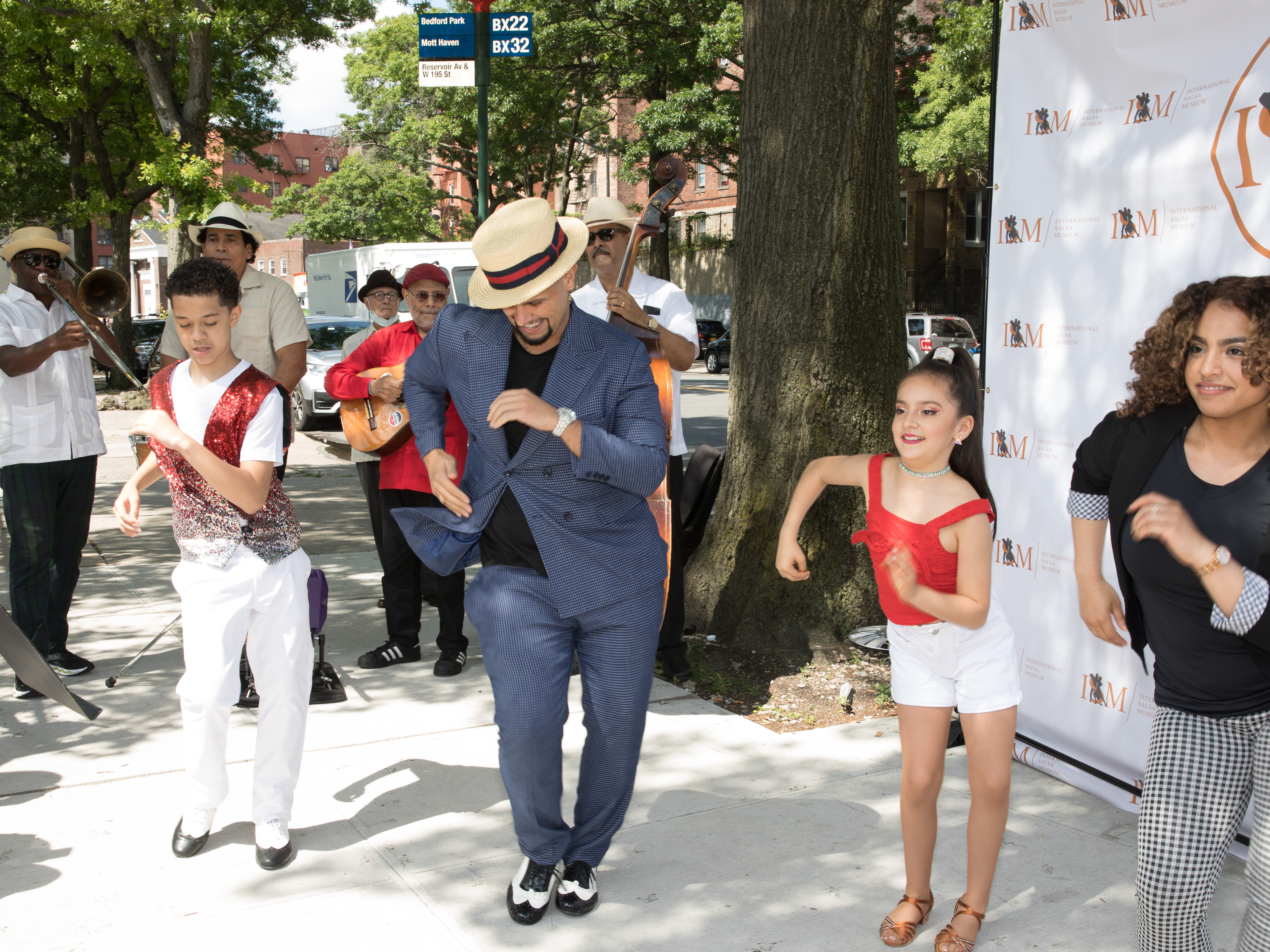 caption: Eddie Torres Jr. and Princess Serrano dance with two young salseros at the first pop-up of the International Salsa Museum