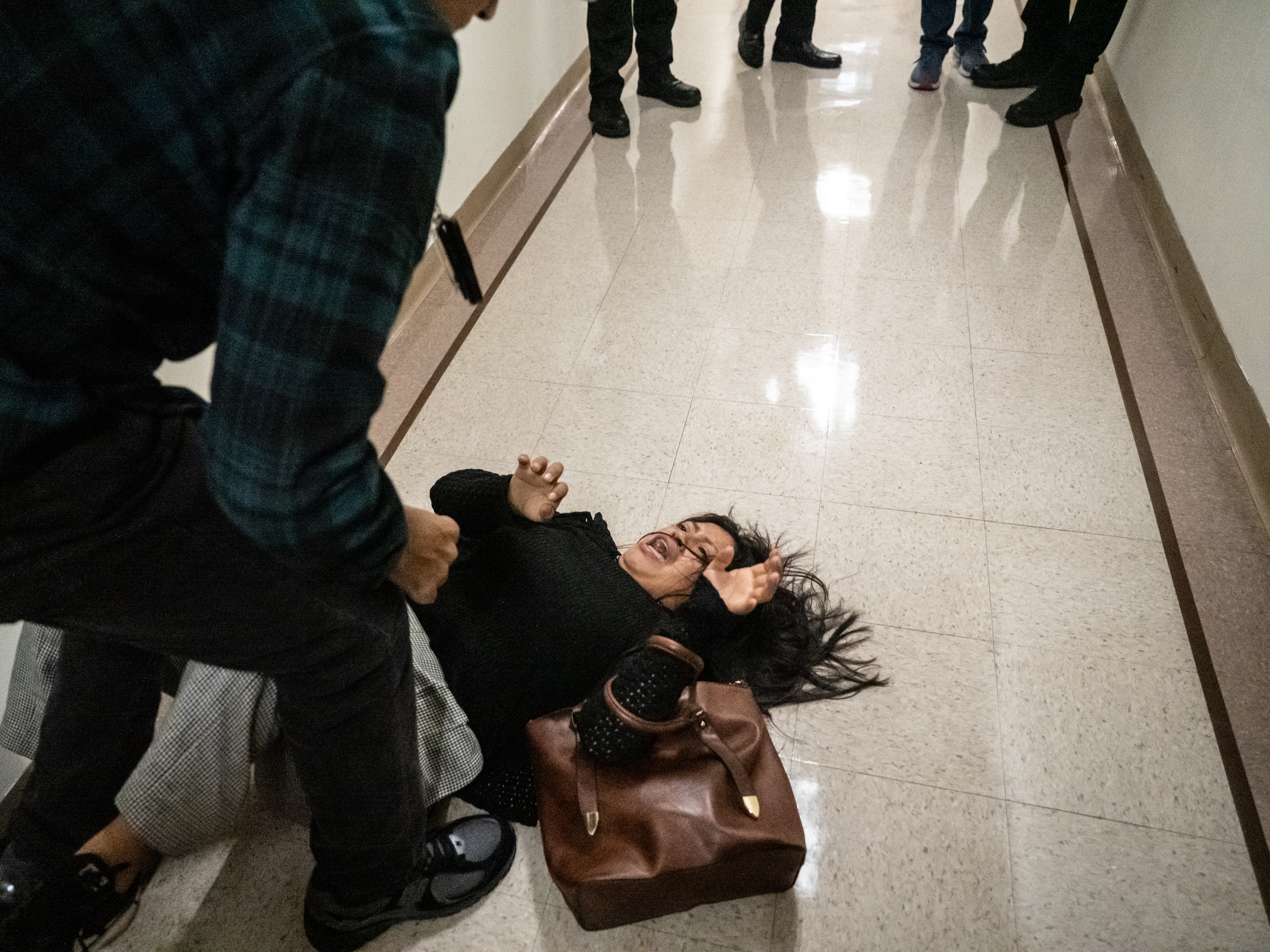 caption: A federal agent pushes the wife of the detained man from Ecuador to the ground on September 25, 2025 in New York City.