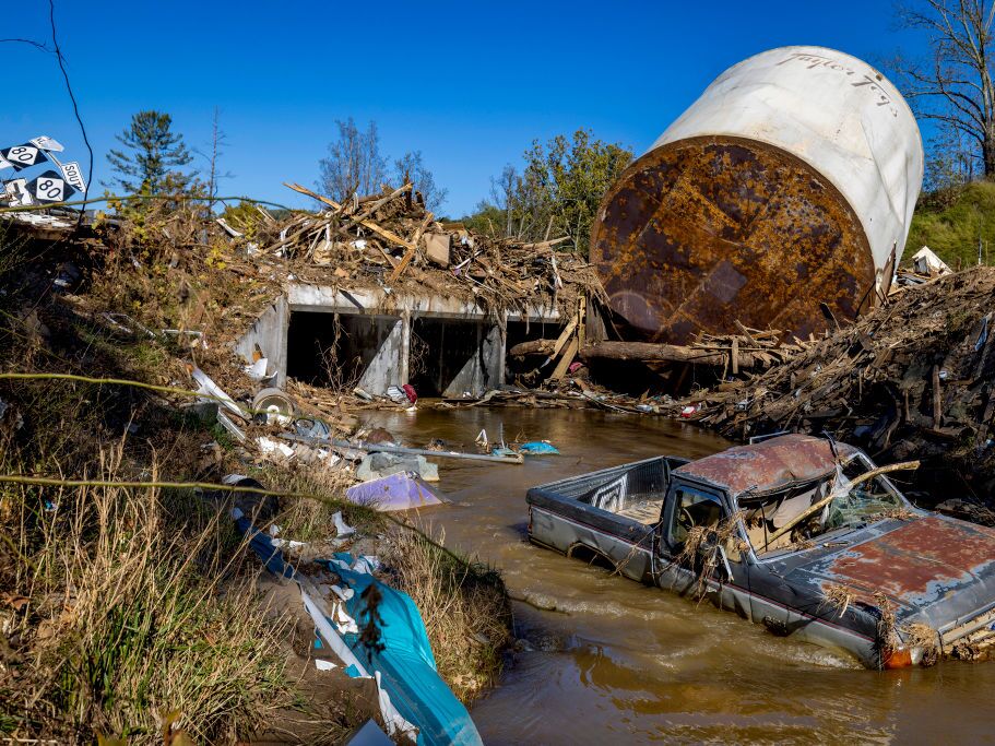 caption: Little Crabtree Creek is littered with storm debris and vehicles, on Thursday, Oct. 17, 2024, three weeks after Hurricane Helene flooded the South Toe River and adjacent creeks near Micaville in Yancey County, N.C.