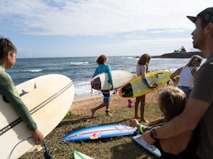 caption: Pro surfers organized a Saturday morning surf session to help kids do something they love at Ho'okipa Beach on the island's north shore. It's about an hour's drive from Lahaina.