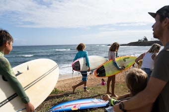 caption: Pro surfers organized a Saturday morning surf session to help kids do something they love at Ho'okipa Beach on the island's north shore. It's about an hour's drive from Lahaina.