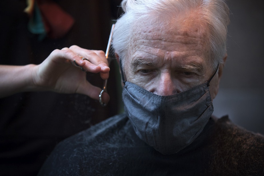 caption: Hair stylist Carter Renee cuts Alan Davidson's hair on Wednesday, October 21, 2020, at the outdoor patio salon that they created outside of their home in Seattle.