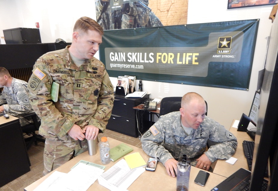 caption: Army Captain Kellam Carmody discusses a recruit's aptitiude test with Army recruiter Kevin Mitchell at the Army Career Center in Tukwila, Washington.