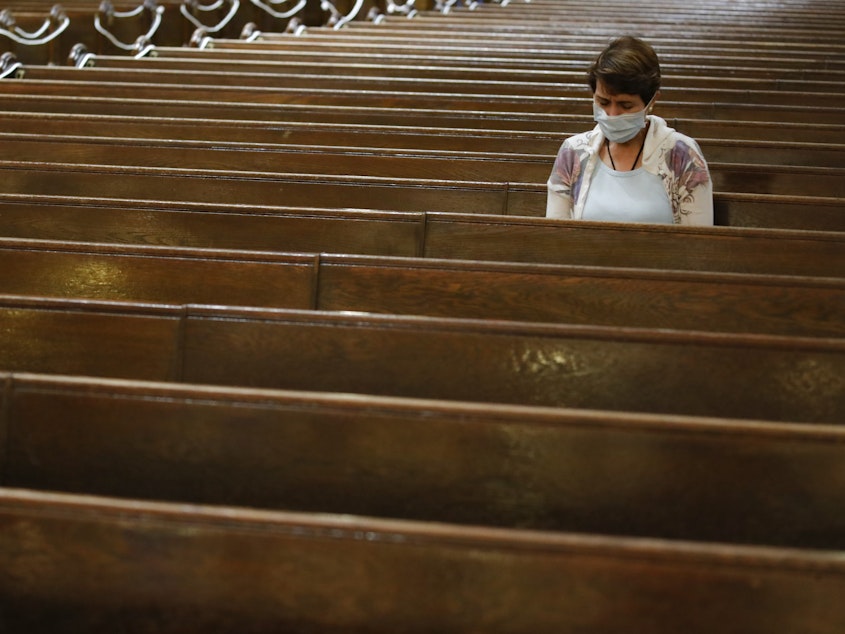 caption: A parishioner sits after Mass last month at a Catholic church in New York City. An overwhelming majority of U.S. adults believe that houses of worship should be subject to the same restrictions on public gatherings that apply to other institutions.