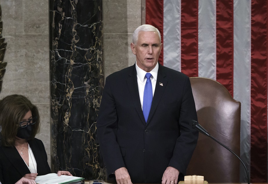 caption: Hours after rioters stormed the Capitol, Vice President Mike Pence listens after reading the final certification of Electoral College votes cast in November's presidential election.