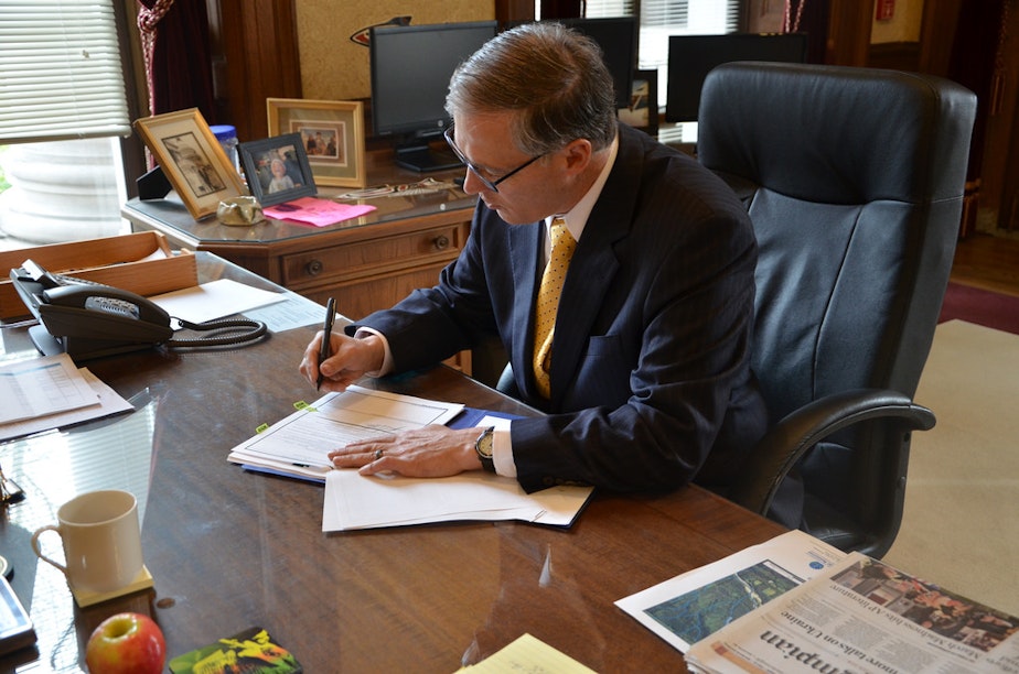 caption: Governor Jay Inslee signs the  request for a Major Disaster Declaration for the Oso mudslide.