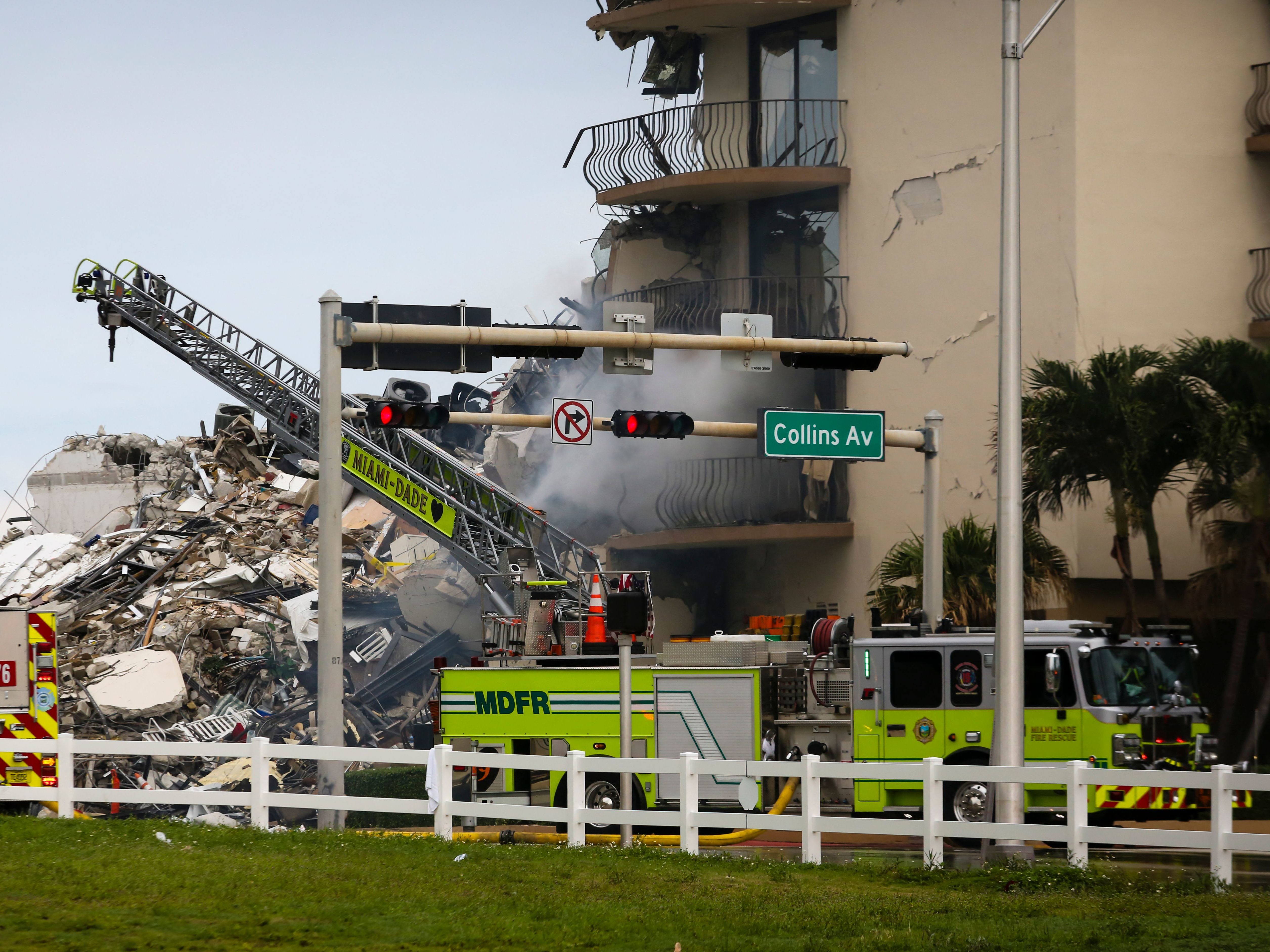 caption: A Miami-Dade Fire Rescue truck is seen Thursday in front of debris from the partially collapsed Champlain Towers South complex in Surfside, Fla., north of Miami Beach.