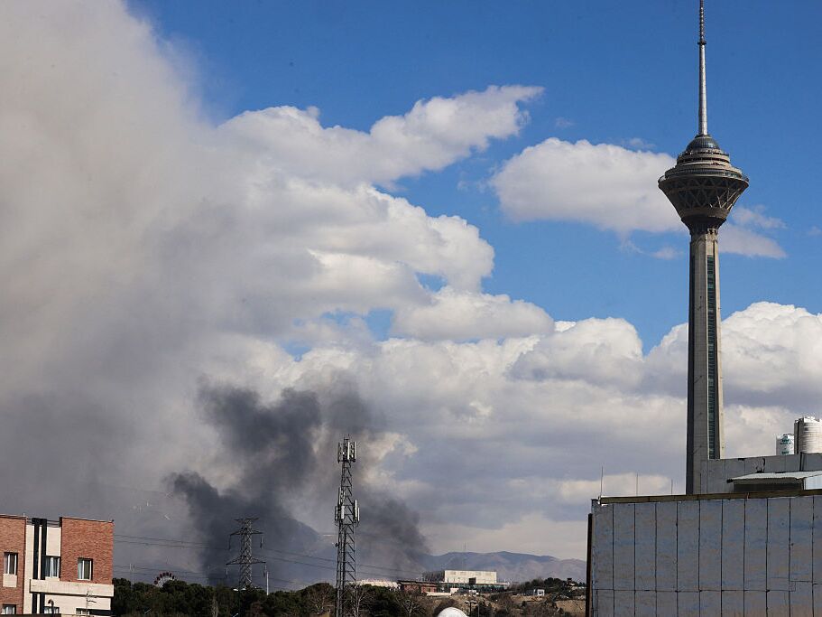 caption: A plume of smoke rises following reported explosions in Tehran on March 1, 2026.