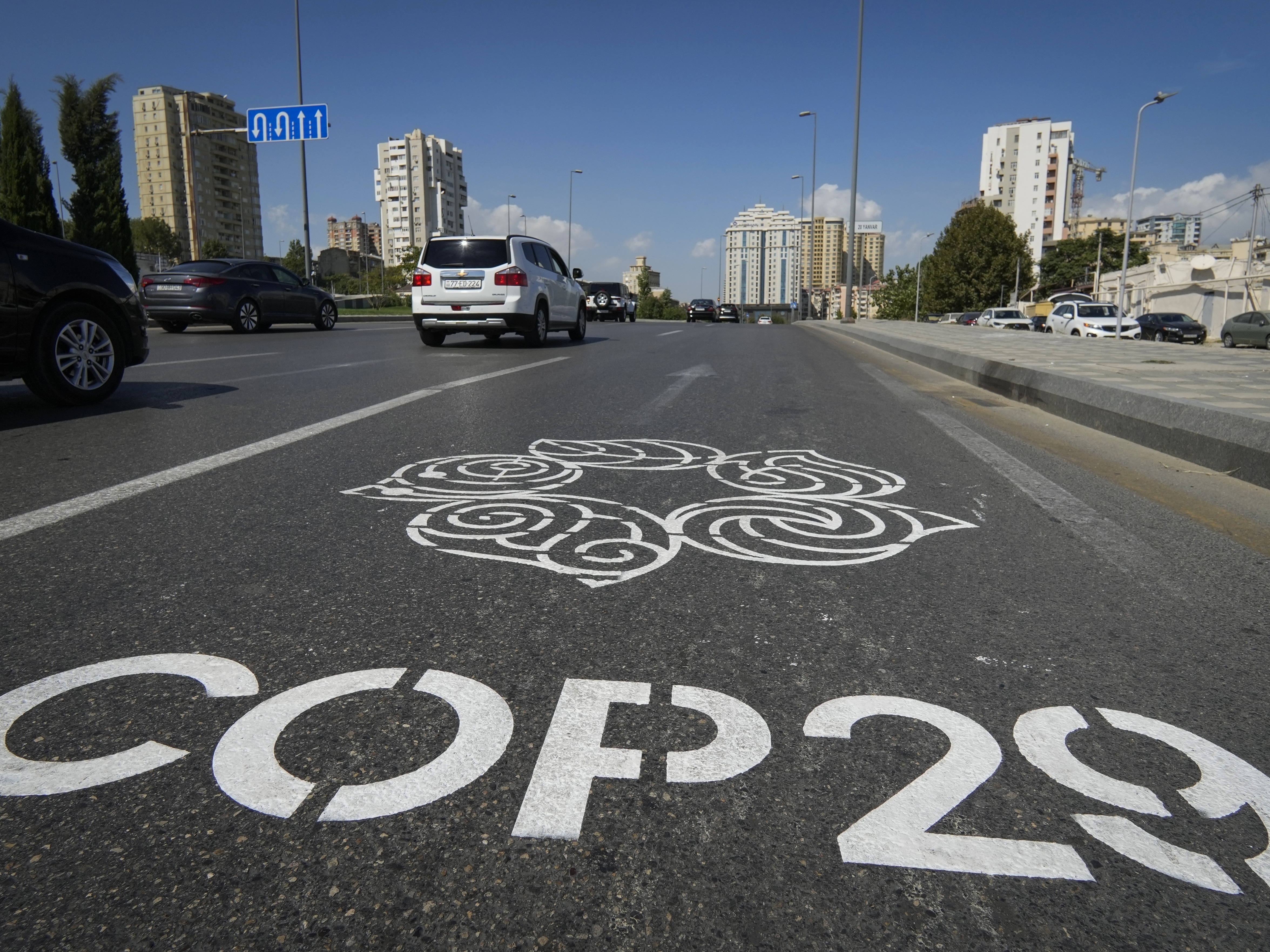 caption: The logo for the COP29 climate change conference is painted on a road in Baku, Azerbaijan.
