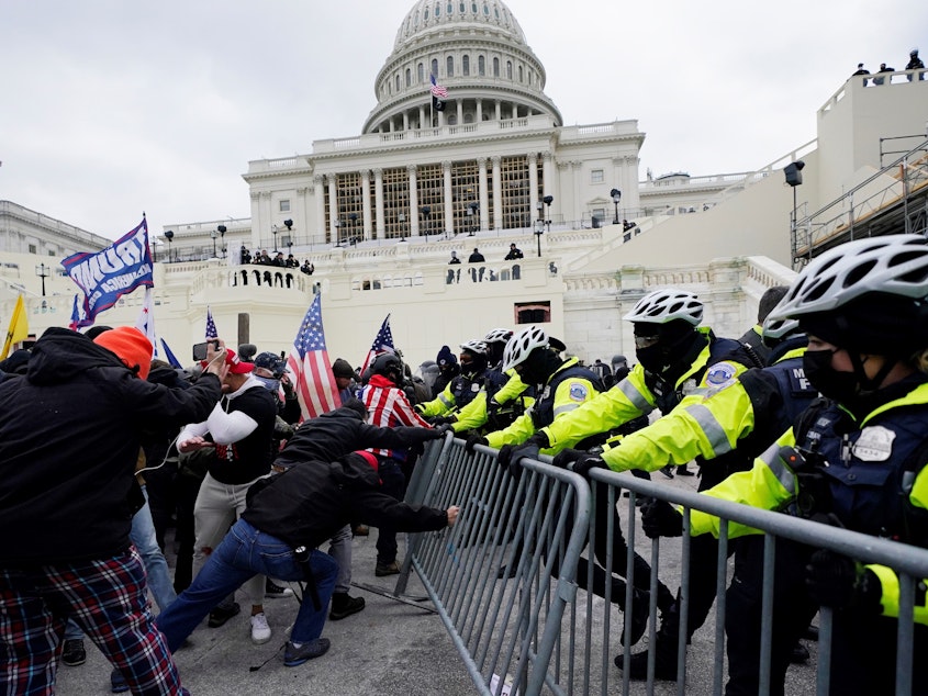 caption: In this Wednesday, Jan. 6, 2021 file photo, Trump supporters try to break through a police barrier at the Capitol in Washington, D.C.