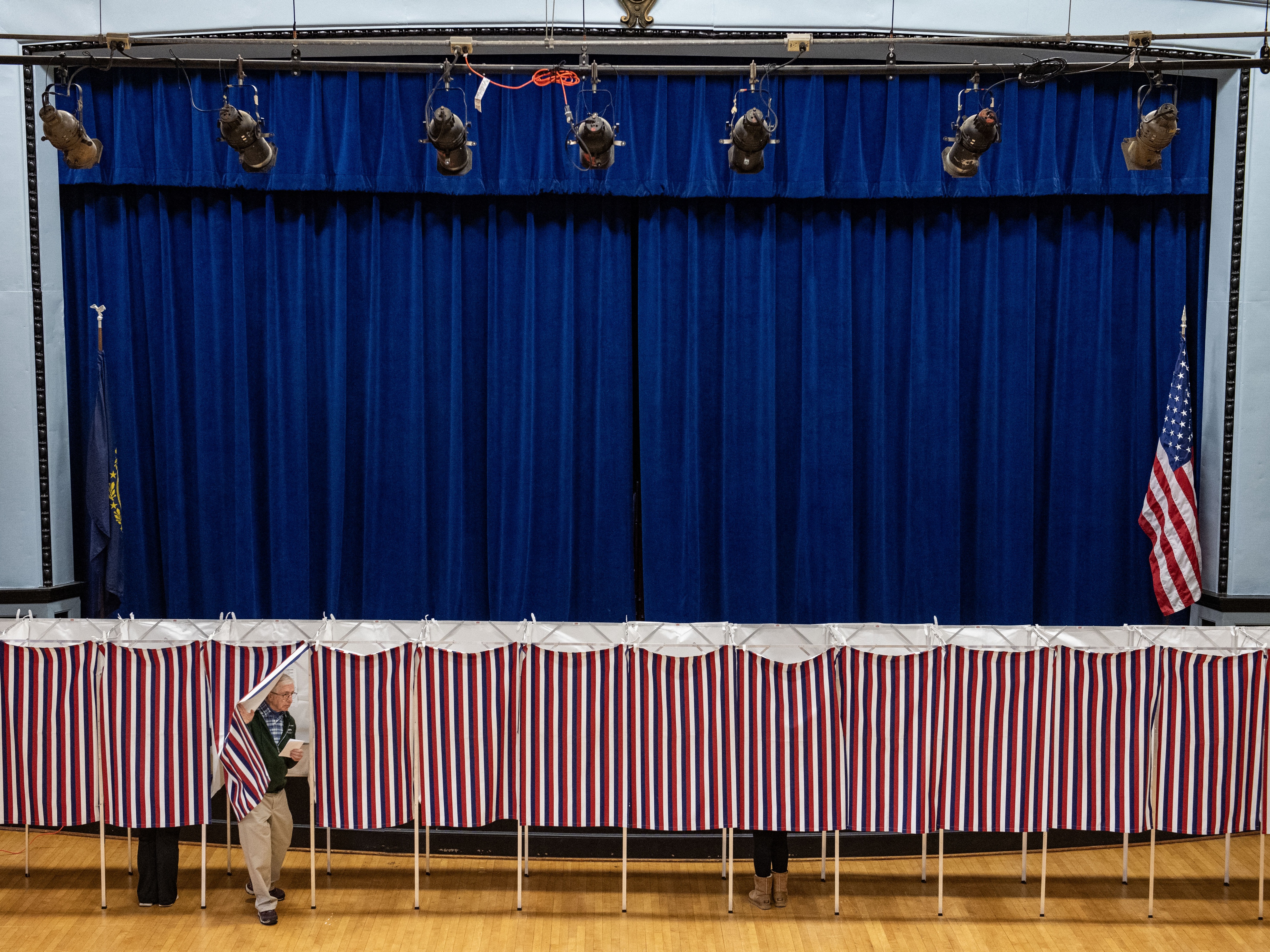 caption: A man exits a voting booth at a polling station in Lancaster, N.H., on Election Day, Nov. 5.