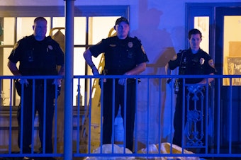 caption: Police officers are stationed outside the Hot Yoga Tallahassee studio after a gunman killed two people and injured several others Friday evening.