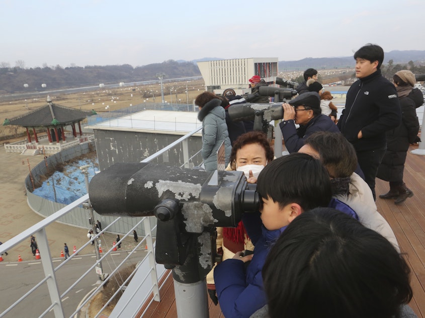 caption: Visitors celebrating the New Year use binoculars to watch North Korean territory Wednesday, near the border between North and South Korea.