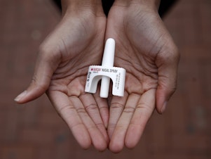 In this Jan. 23, 2018 photo, Leah Hill, a behavioral health fellow with the Baltimore City Health Department, displays a sample of Narcan nasal spray in Baltimore. Public health officials say the drug is a critical tool in addressing America's opioid epidemic. (AP Photo/Patrick Sema