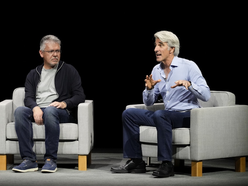 caption: Apple software chief Craig Federighi, right, pictured with exec John Giannandrea, announced a partnership with OpenAI to bring AI features to its products. (AP Photo/Jeff Chiu)