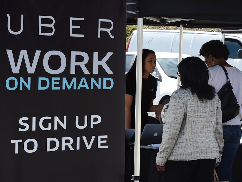 People sign up to become Uber drivers at the first of Uber's 'Work On Demand' recruitment events.