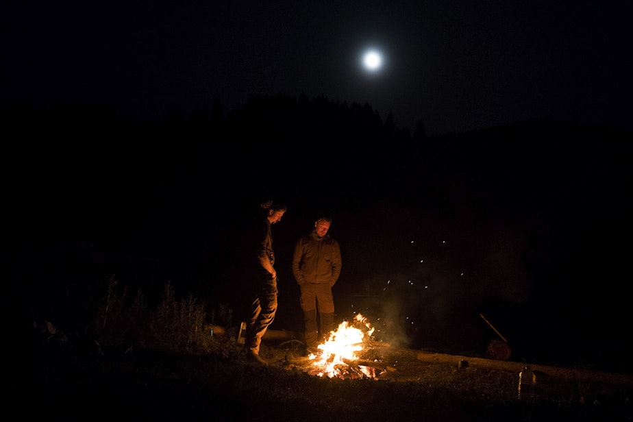 caption: Rangerider Daniel Curry, left, and host of The Wild, Chris Morgan, right, stand at a fire as the moon rises on Monday, October 14, 2019, near Danville. 