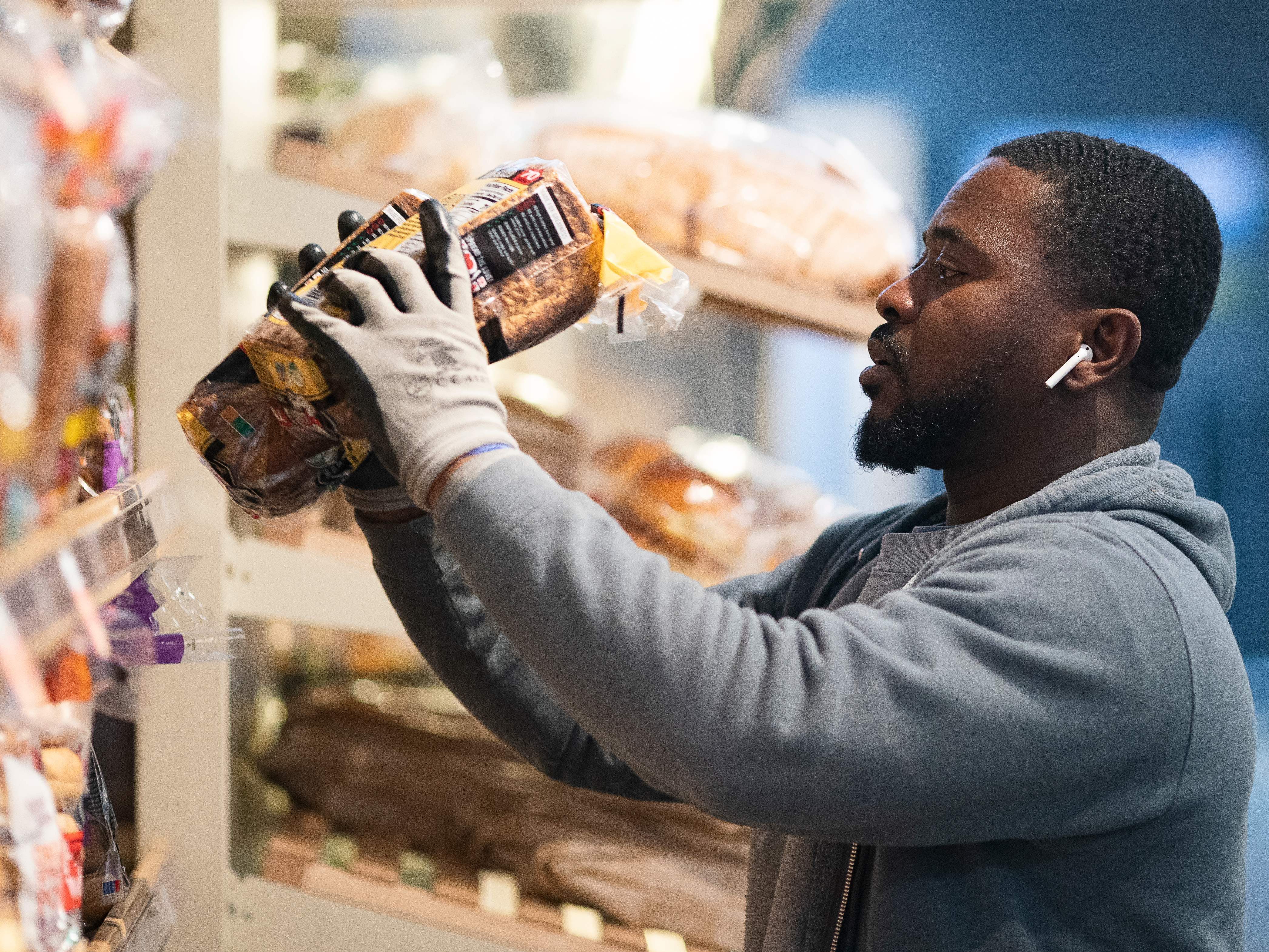 caption: A grocery store worker stocks bread at a MOM's Organic Market in Washington, D.C., on April 2. Last week, bread sales jumped 30% compared to a year ago. But yeast sales were up more than 450%.