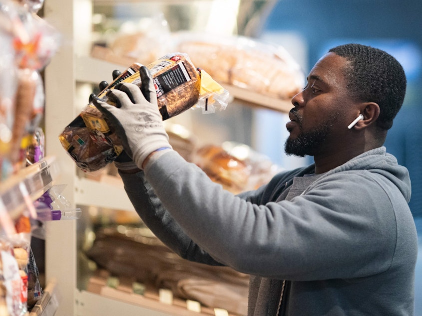 caption: A grocery store worker stocks bread at a MOM's Organic Market in Washington, D.C., on April 2. Last week, bread sales jumped 30% compared to a year ago. But yeast sales were up more than 450%.