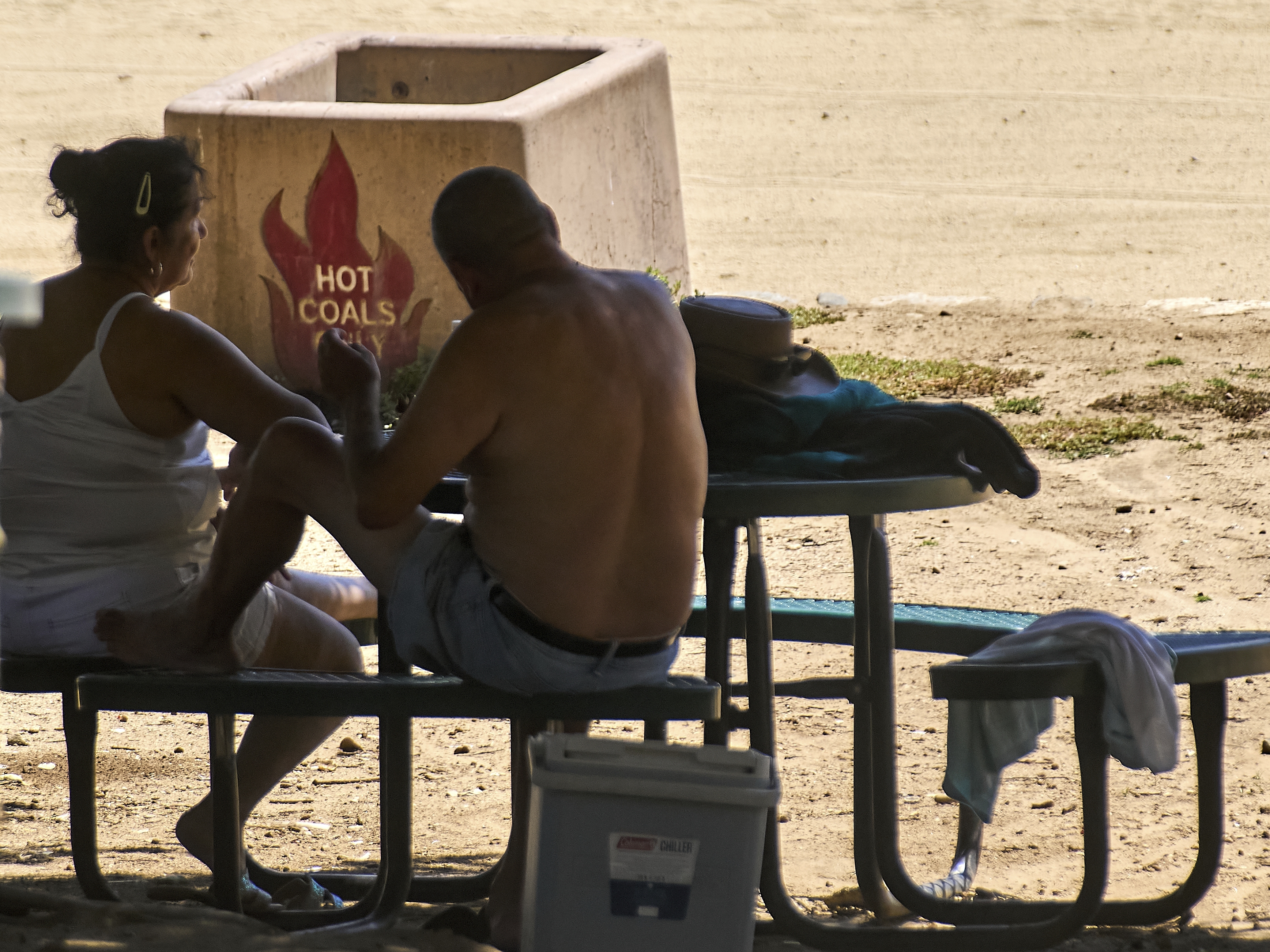 caption: A couple sits in the shade as temperatures rise on Wednesday at Castaic Lake in Los Angeles County, Calif.