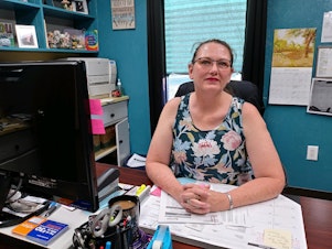 caption: Donna Dunn, 49, works as the office manager at a healthcare clinic in Booker, Texas. Despite getting a raise, she has struggled to pay her family's bills as prices have risen faster than her paycheck.