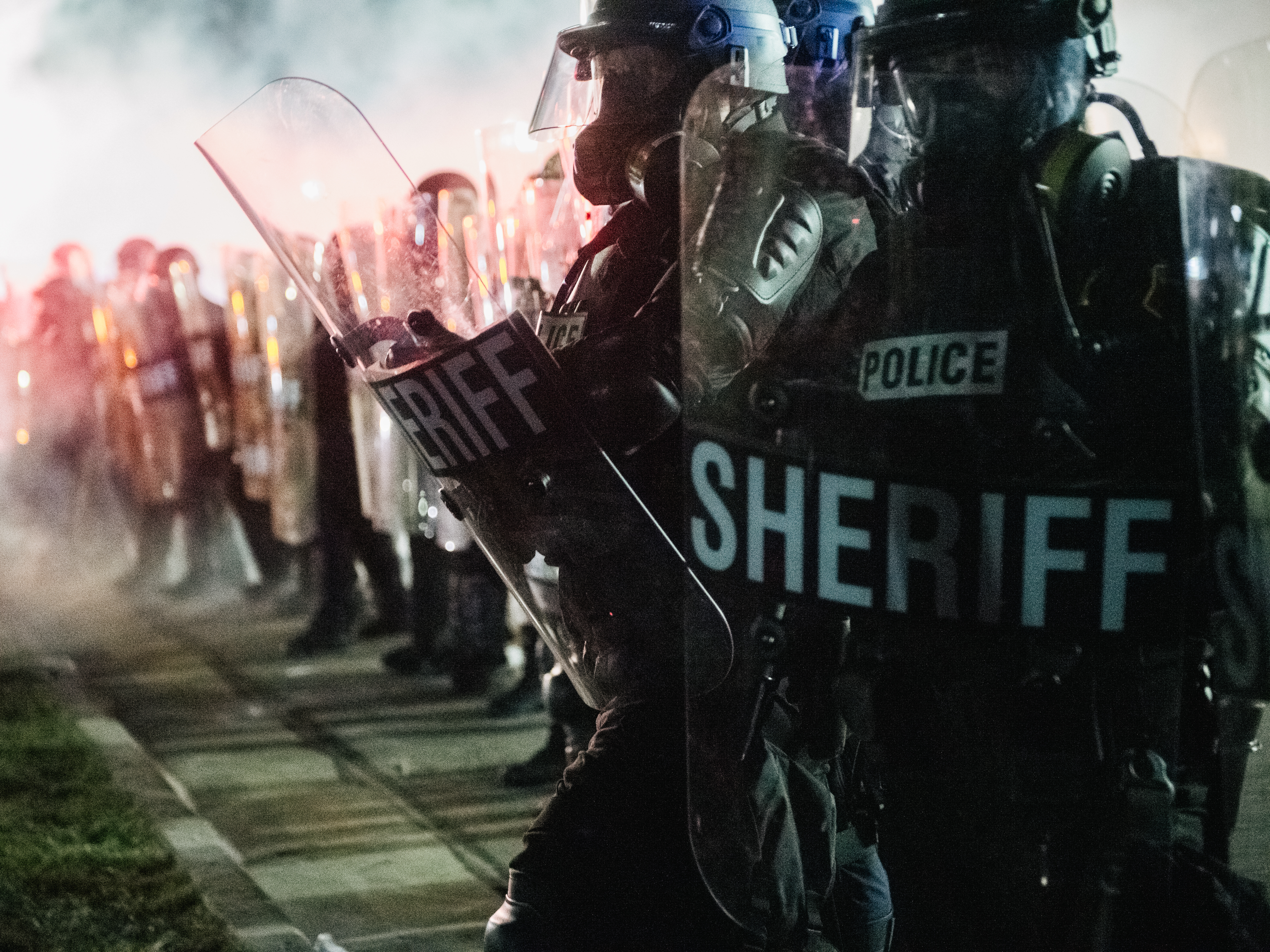 caption: Law enforcement holds a line Tuesday in Kenosha, Wis. The union representing police officers in Kenosha says Jacob Blake, who was shot multiple times at close range and severely wounded by a police officer, was armed with a knife.