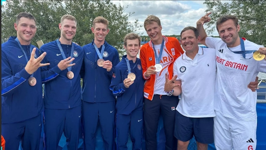 caption: University of Washington alumni and now Olympic medal winners after the final regatta Saturday in Paris: (from left) Chris Carlson, Evan Olson, Pieter Quinton, Rielly Milne, Gert-Jan van Doorn, coach Michael Callahan, and Jacob Dawson.