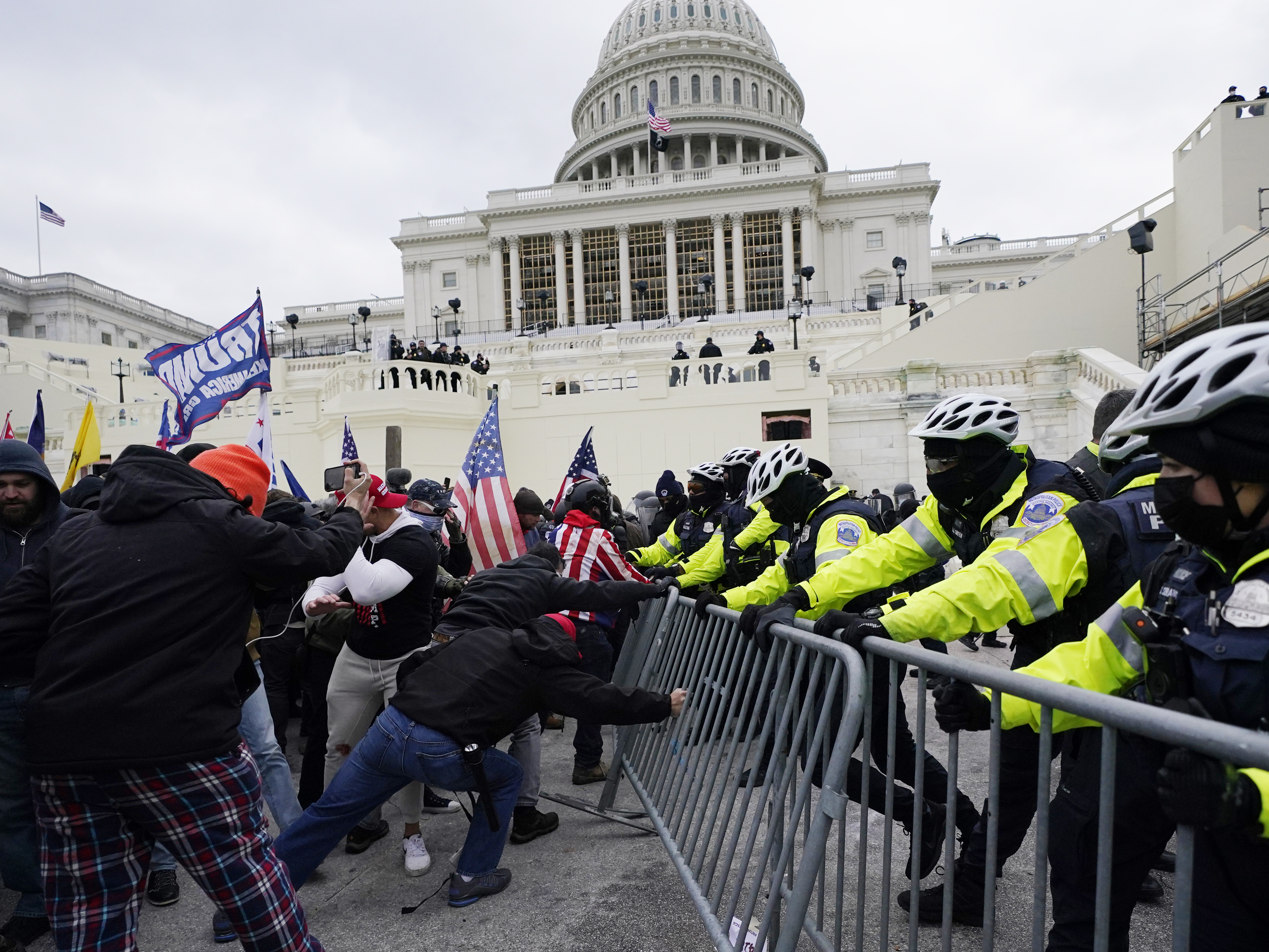 caption: In this Jan. 6, 2021 file photo, rioters try to break through a police barrier at the Capitol in Washington.