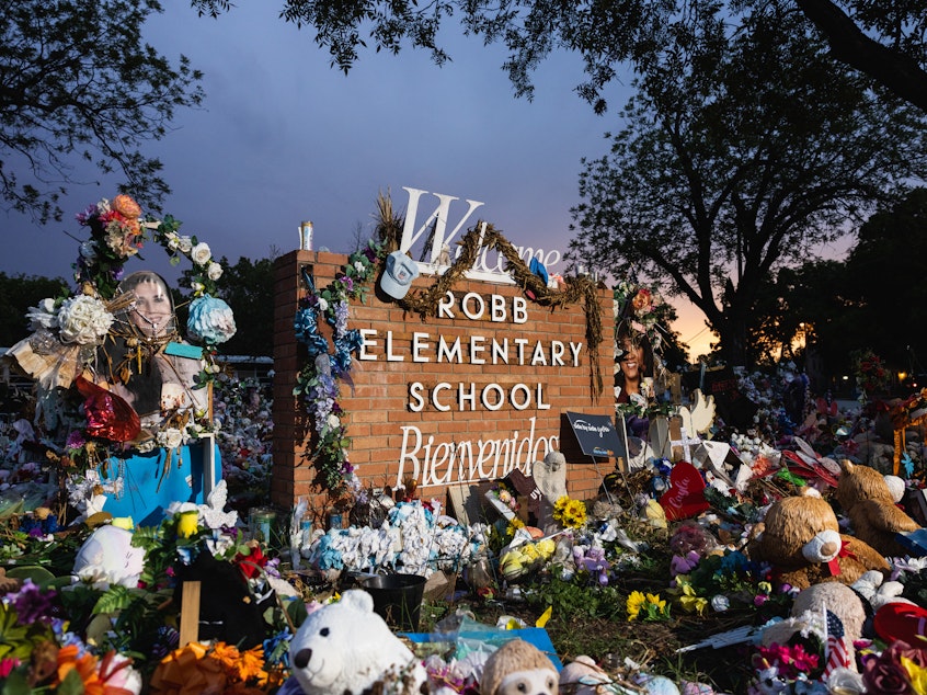 caption: The sun sets behind the memorial for the victims of the massacre at Robb Elementary School in August 2022 in Uvalde, Texas.