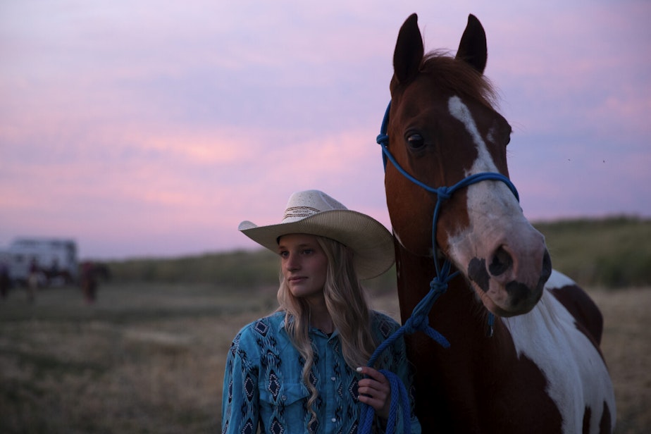 caption: Faith Perkins, 20, of Benton City, stands with her horse Bolero on Friday, June 17, 2022, at the Freedom Rodeo in Basin City.
