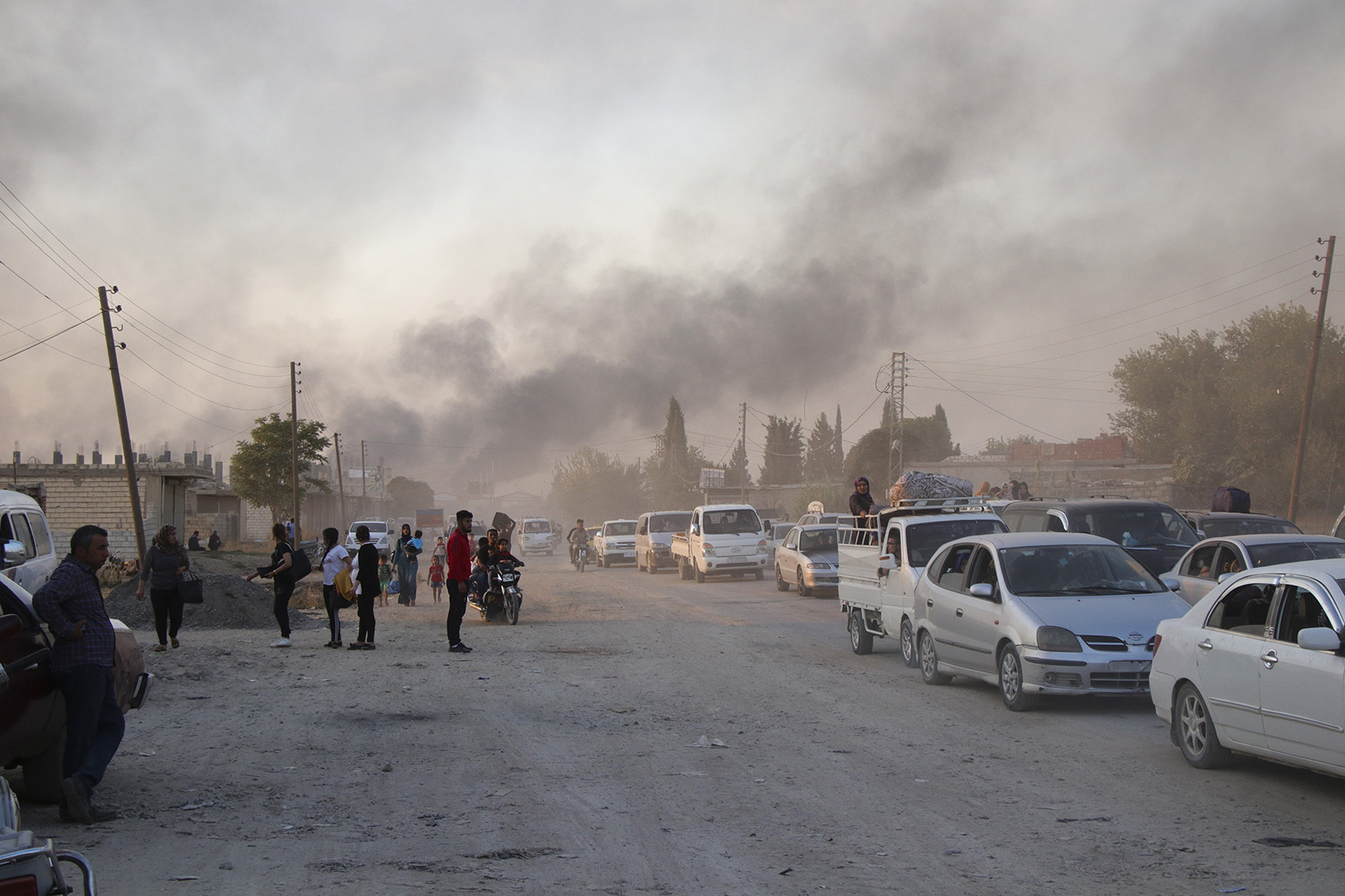 caption: Syrians flee shelling by Turkish forces in Ras al Ayn, northeast Syria, Wednesday, Oct. 9, 2019. Turkish President Recep Tayyip Erdogan announced Wednesday the start of a Turkish military operation against Kurdish fighters in northeastern Syria. (AP Photo)