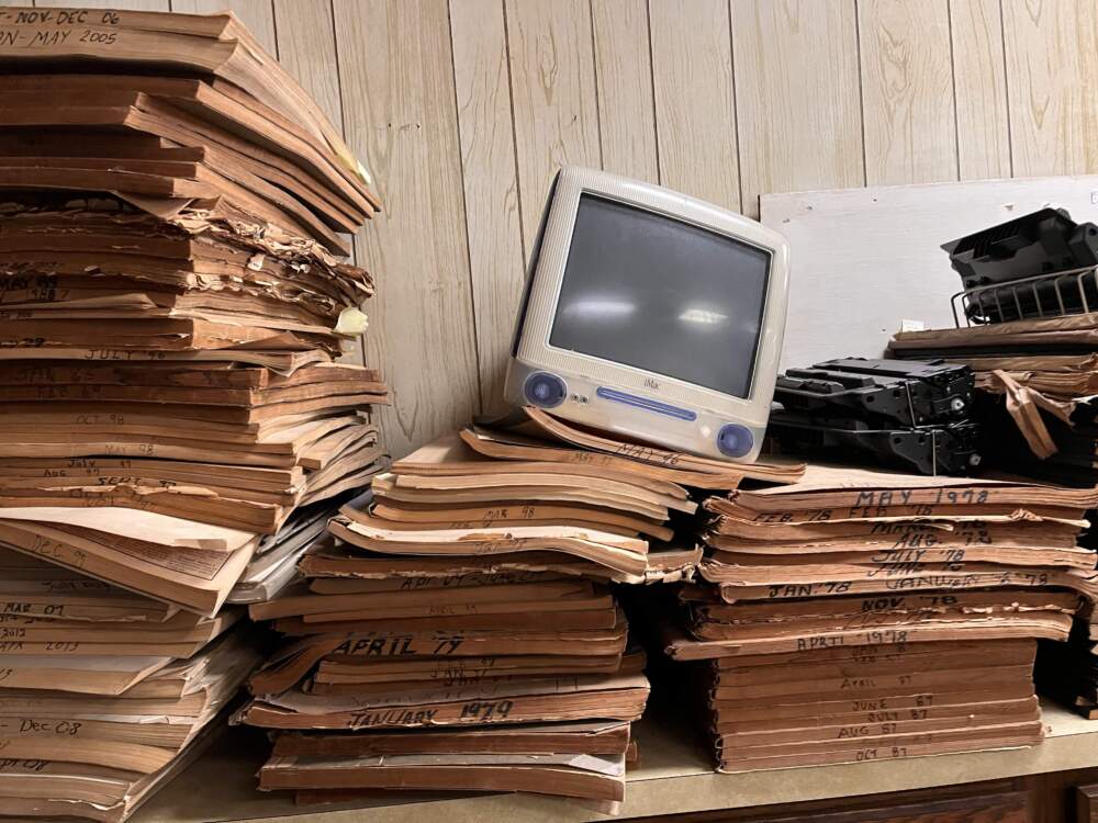 caption:  A discarded iMac rests on top of bound copies of The Welch News. (Todd Melby)
