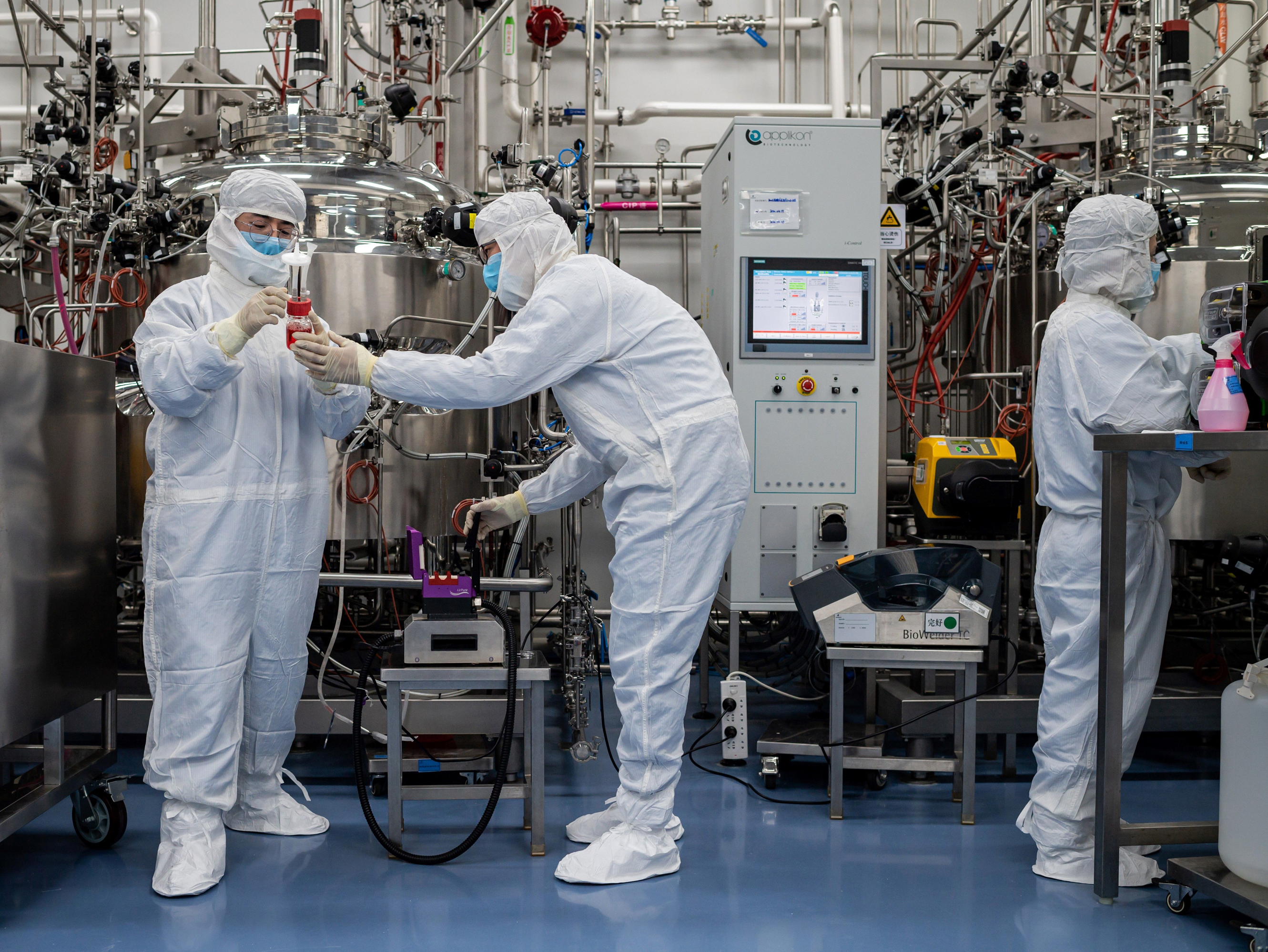 caption: Engineers work on a potential vaccine for the coronavirus at a Beijing lab.