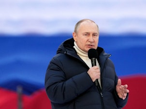 caption: Russian President Vladimir Putin gives a speech at a concert marking the eighth anniversary of Russia's annexation of Crimea at the Luzhniki stadium in Moscow on March 18, 2022.