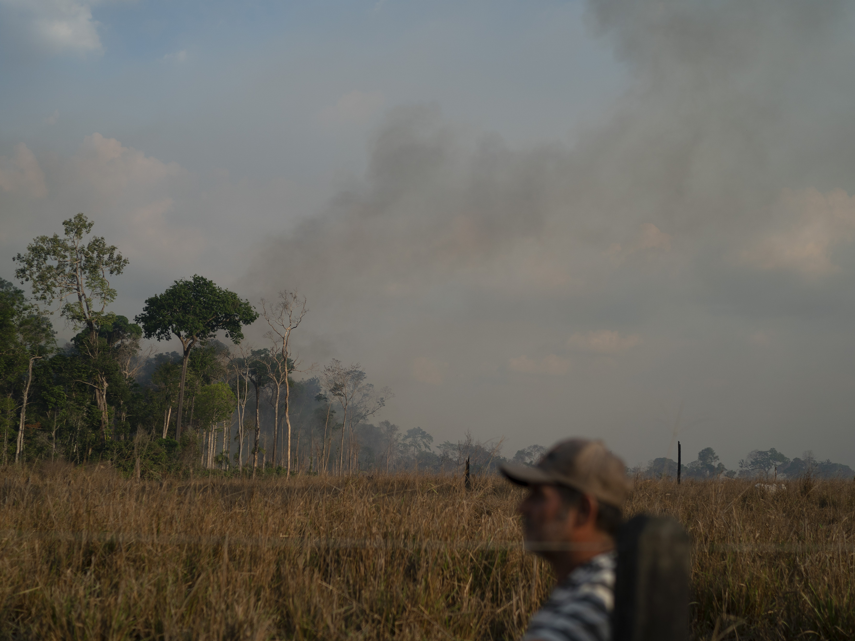 caption: Moacir Cordeiro, who works in a local cattle farm, looks on after digging grooves with a tractor in an attempt to stave off fires in the Alvorada da Amazonia region in Novo Progresso, Para state, Brazil, on Sunday.