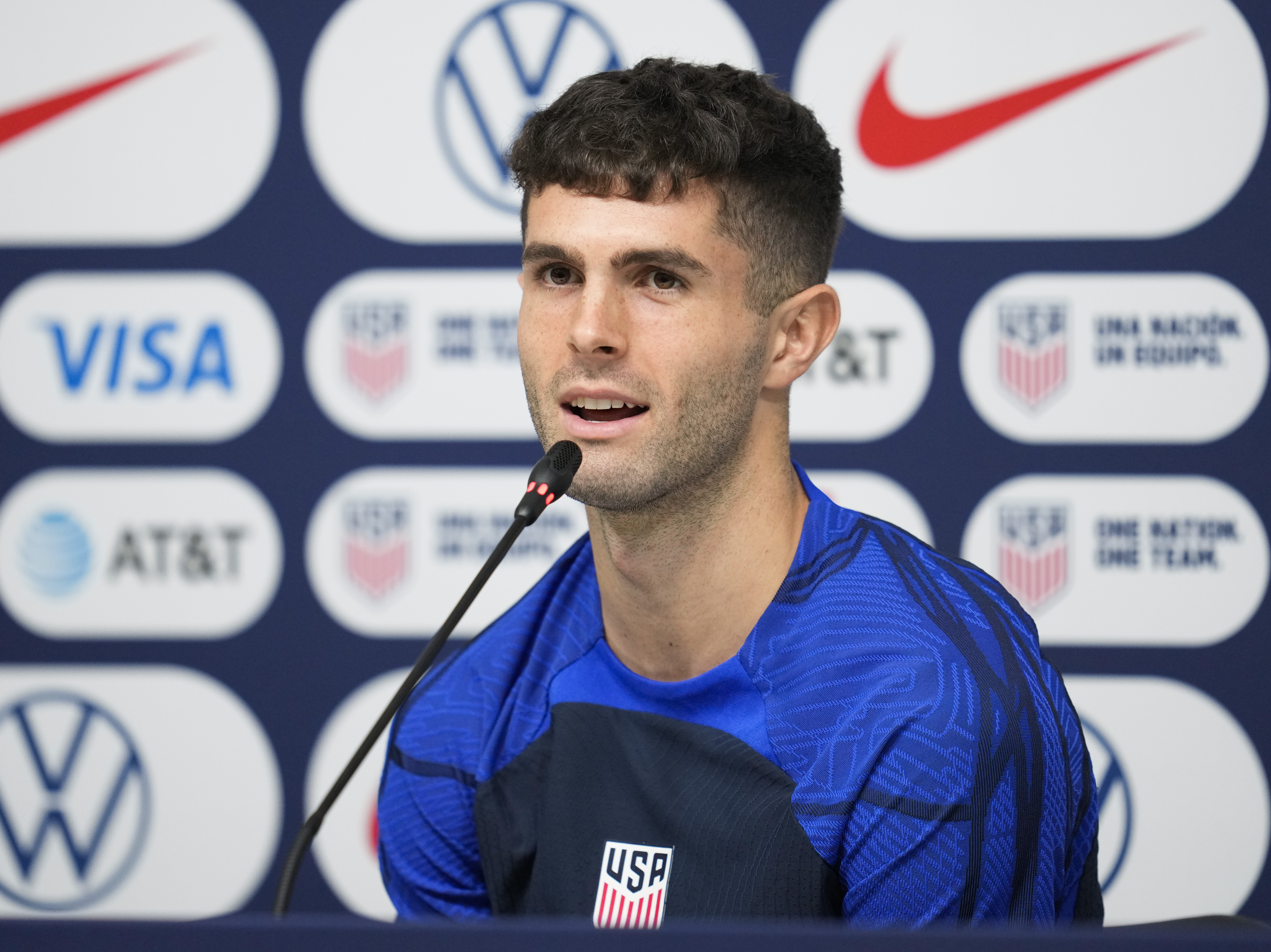 caption: Christian Pulisic of the United States attends a news conference before a training session at Al-Gharafa SC Stadium, in Doha, Thursday, Dec. 1, 2022.