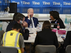 caption: President Biden works the phones during a grassroots volunteer event with the Oregon Democrats at the SEIU Local 49 in Portland, Ore., on Friday.