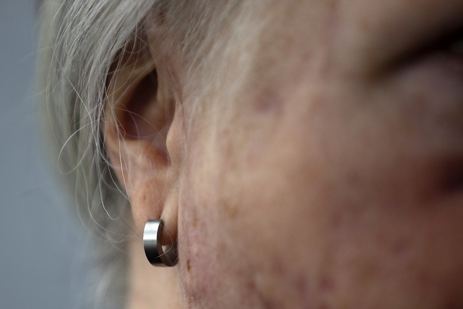caption: Keri Bergere, a survivor of a recent cougar attack, is portrayed on Wednesday, March 13, 2024, at Log Boom Park in Kenmore. The earring in Bergere's right ear was swallowed by the cougar and later mailed back to her.