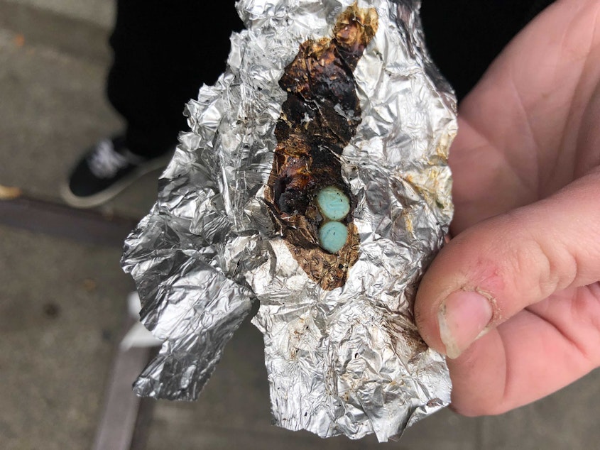 caption: A drug user displays two blue fentanyl pills she is smoking in downtown Seattle, October 22, 2021. Seattle's ordinance making drug possession and public use a gross misdemeanor took effect October 20, 2023. 