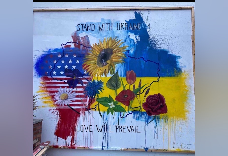 caption: Artist Hillarie Isackson incorporates graffiti to make a new mural in support of Ukraine
