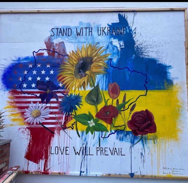 caption: Artist Hillarie Isackson incorporates graffiti to make a new mural in support of Ukraine
