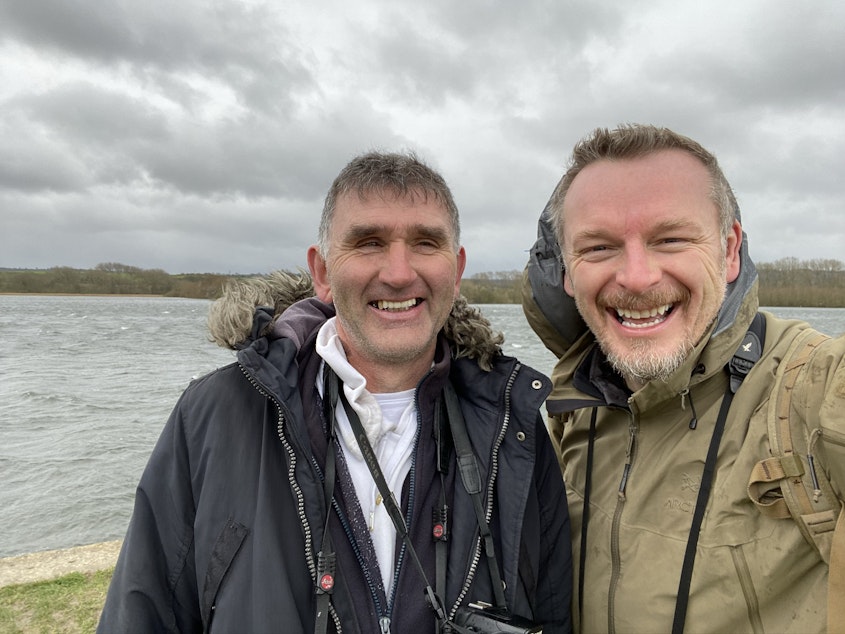 caption: English bird watcher Lee Evans (left) along with THE WILD host Chris Morgan (right) pose while looking for birds. 